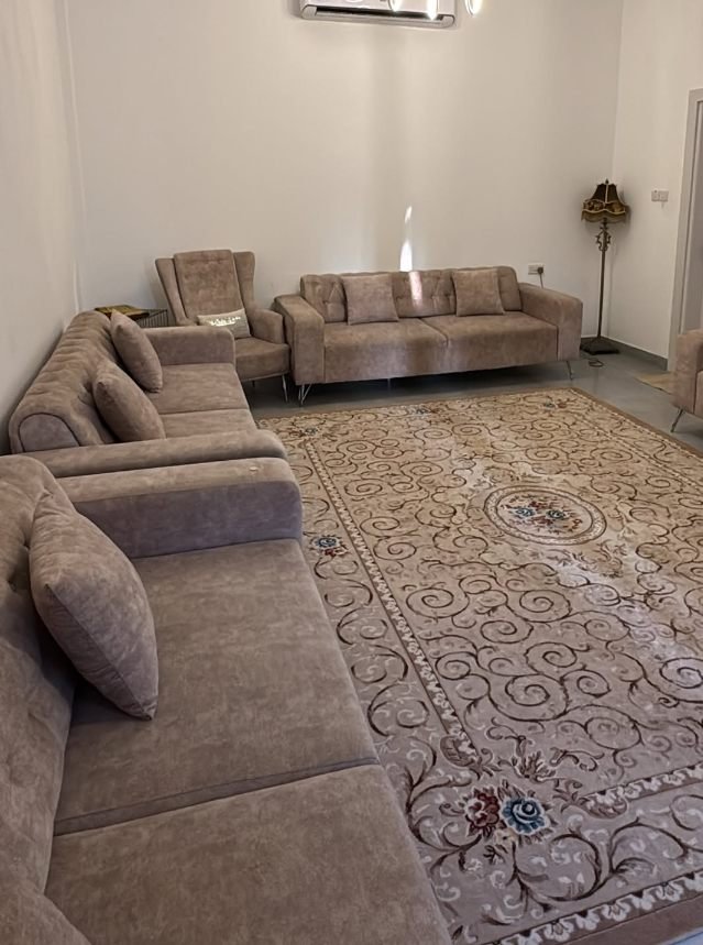 Grand majlis with sectional seating and patterned rug